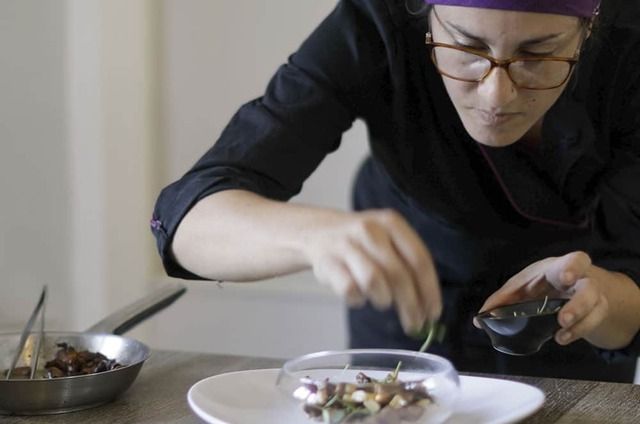 Photo d'une cheffe cuistot en train de dresser une assiette