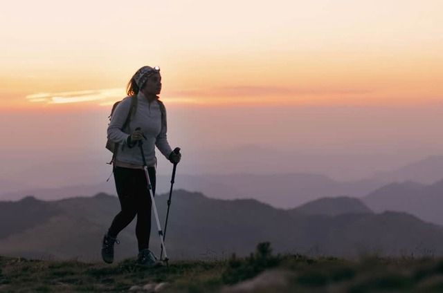 Photo d'une randonneuse dans les pyrénées ariégeoises au lever du soleil